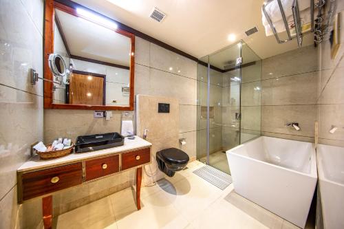 La salle de bains est pourvue d'une baignoire, d'un lavabo et d'une douche. dans l'établissement Apple Orchard Resort & Spa, à Srinagar