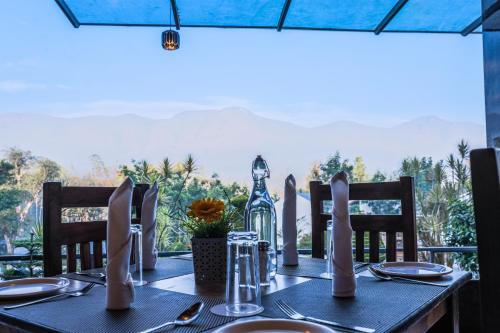 a table with chairs and a table with a table cloth sidx sidx sidx at The Blossom Resort - Chikmagalur in Chikmagalūr