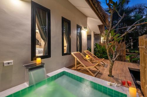 una piscina en una casa con mesa y sillas en At Rice Resort en Nakhon Nayok