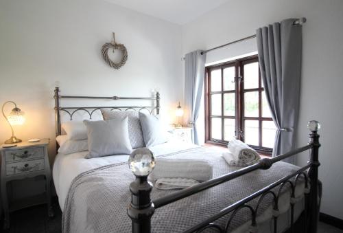 a bedroom with a large bed with a window at Jasmine Cottage, Buxton Norfolk, Sleeps 4 in Norwich