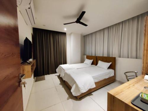 a bedroom with a bed and a ceiling fan at Hotel Hibiscus Tree- Bachupally in Hyderabad