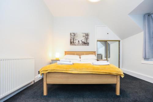 una camera da letto con un letto con una coperta gialla sopra di mySTAYINN Tomnahurich 3 Bedroom House a Inverness