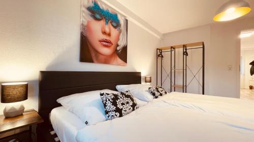 a bedroom with a bed with a picture of a woman at AR Apartments I 4 Pers I Prime I Küche I WLAN I Office in Rudolstadt