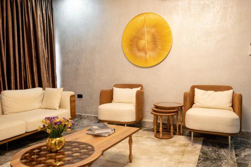 a living room with two chairs and a table at YANNA APARTMENT BY KHALIQUES in Abuja
