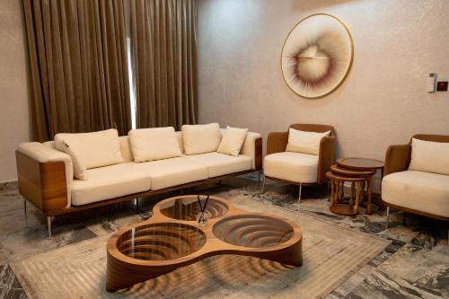 a living room with a couch and chairs and a clock at YANNA APARTMENT BY KHALIQUES in Abuja