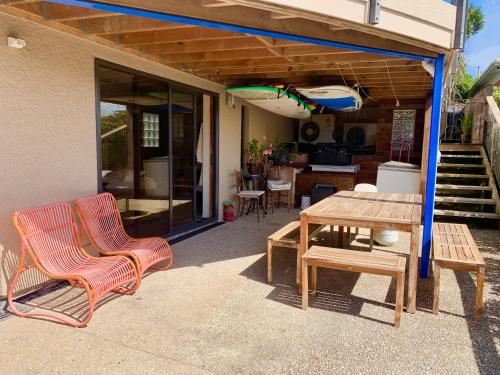 un patio con 2 sedie e un tavolo in legno di Otago Peninsula Paradise a Dunedin