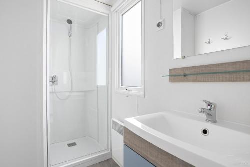 a white bathroom with a sink and a shower at First Camp Ekerum - Öland in Borgholm