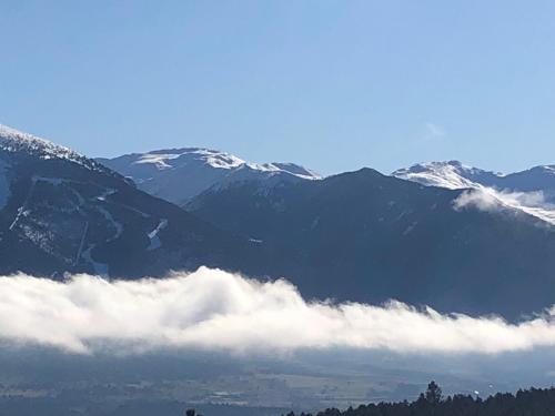 Un groupe de montagnes avec des nuages devant elles dans l'établissement Studio cabine, à Bolquère-Pyrénées 2000