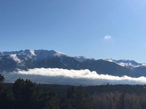Une montagne enneigée avec des nuages au premier plan dans l'établissement Studio cabine, à Bolquère-Pyrénées 2000