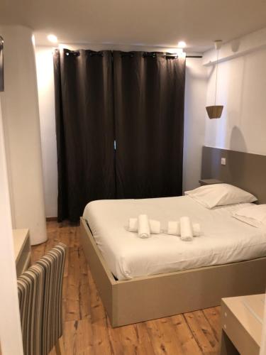 モンペリエにあるHôtel Saint Roch Montpellier Centreのベッドルーム1室(黒いカーテン付きのベッド1台付)