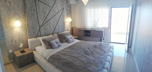 a bedroom with a large bed with purple pillows at W Apartment in Chania