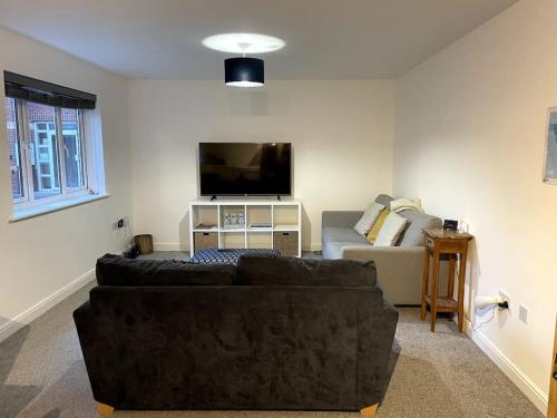 グロスターにあるLarge 2 bedroom apartment, 4 beds one 1 en-suite, Free parking Nr Chelt Elmore and Quaysのリビングルーム(ソファ、薄型テレビ付)