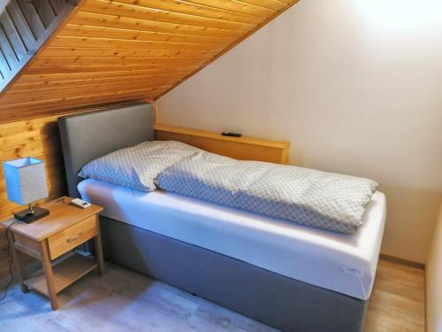 a bed in a room with a wooden ceiling at Appartement "Toni" 