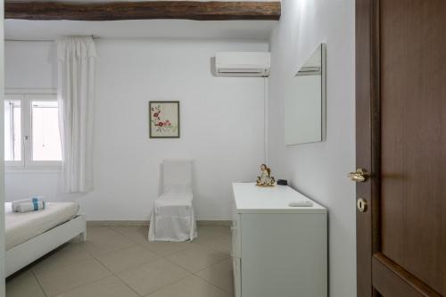 Habitación blanca con mesa y ventana en Casa Vacanza Il Murales, en Loceri