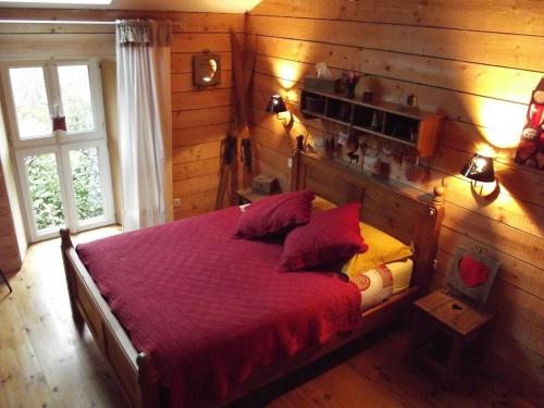 - une chambre avec un lit et une couverture rouge dans l'établissement La Chaussee d'Olivet en Mayenne, à Olivet