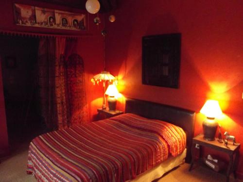 a red bedroom with a bed with two lamps on it at La Chaussee d'Olivet en Mayenne in Olivet