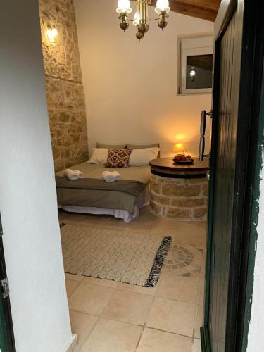 a bedroom with a bed and a stone wall at Sterna in Mesovounion-Zagori