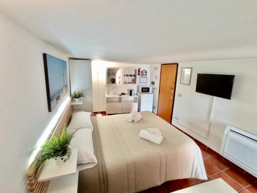 Habitación pequeña con 2 camas y TV. en HomeClass Mercantile, en Bari