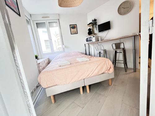 ein kleines Schlafzimmer mit einem Bett und einem Fenster in der Unterkunft Le Tressous - Studio sur place de Jaude Prefecture in Clermont-Ferrand
