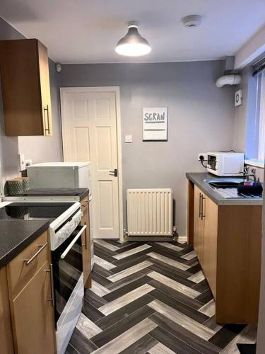 a kitchen with a checkered floor in a kitchen at 2 bedroom home with free parking in Gateshead