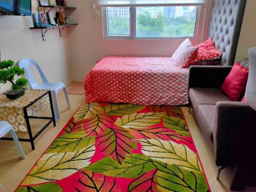a living room with a bed and a colorful rug at One Bedroom Apartment at Avida Tower 2 in Iloilo City