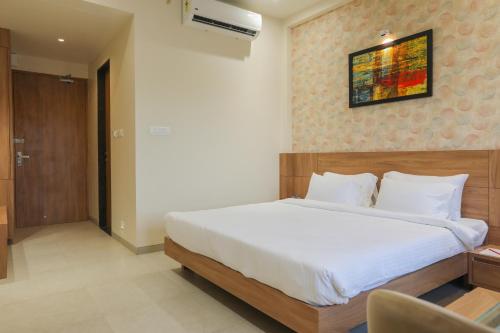 a bedroom with a large white bed in a room at Enrise by Sayaji, Khed Shivapur Pune in Pune