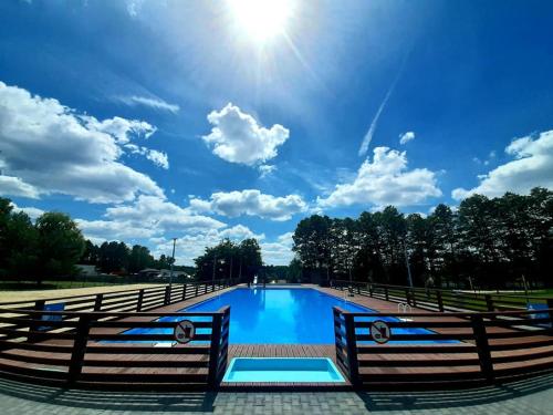 ein Schwimmbad mit der Sonne am Himmel in der Unterkunft Miejsko Gminny Ośrodek Sportu i Rekreacji in Łopuszno