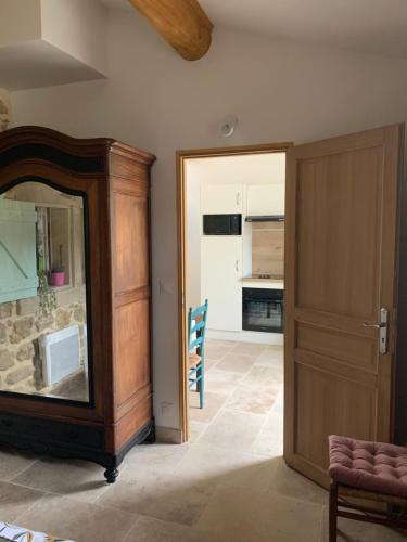 ein Wohnzimmer mit einer Tür und eine Küche in der Unterkunft LA MAGNANERIE in Grillon