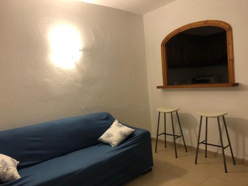 sala de estar con sofá azul y 2 taburetes en Son Parc Menorca recién reformado!, en Son Parc
