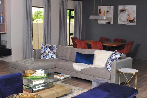 a living room with a couch and a table at Square Connexions Guest House in Gaborone