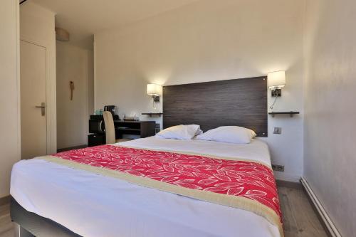 a bedroom with a large bed with a red blanket at Hotel Cayrons Vence & St Paul de Vence in Vence