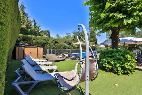 a group of chairs and a swing in a yard at Hotel Cayrons Vence & St Paul de Vence in Vence