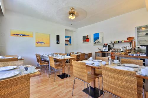 a dining room with wooden tables and chairs at Hotel Cayrons Vence & St Paul de Vence in Vence