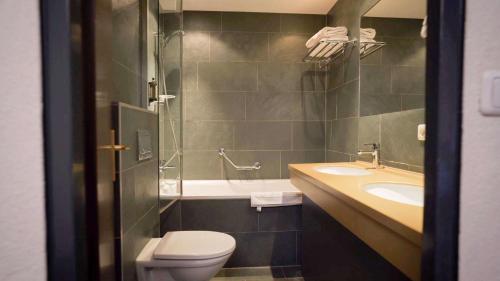 a bathroom with a toilet and a sink and a shower at Hotel Rosanna by Alpeffect Hotels in Sankt Anton am Arlberg