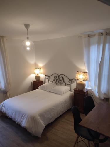 a bedroom with a bed with two lamps and a table at Château le haut villaumay in Auzouer-en-Touraine