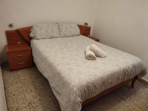 een slaapkamer met een bed met een telefoon erop bij Habitaciones Valén in Zaragoza
