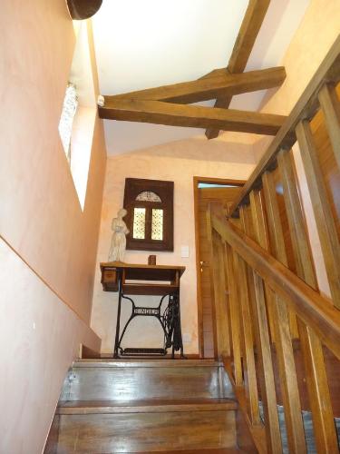 a wooden staircase with a table in a room at La maison du Fargis in Auffargis