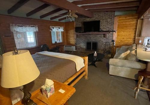 a bedroom with a bed and a couch and a table at Olde Mill Inn of Clarkston in Clarkston