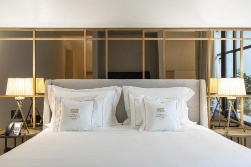 a bedroom with a white bed with white pillows at Casa da Companhia Hotel & Spa, Vignette Collection by IHG in Porto