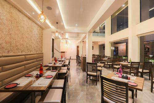 a dining room with long tables and chairs at Enrise by Sayaji, Khed Shivapur Pune in Pune