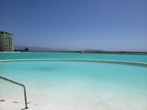 a swimming pool with blue water on a beach at Laguna Del Mar La Serena boutique in La Serena