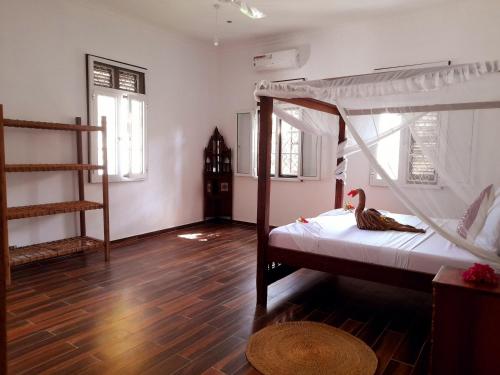 a bedroom with a bunk bed and a wooden floor at Culture's apartment in Paje