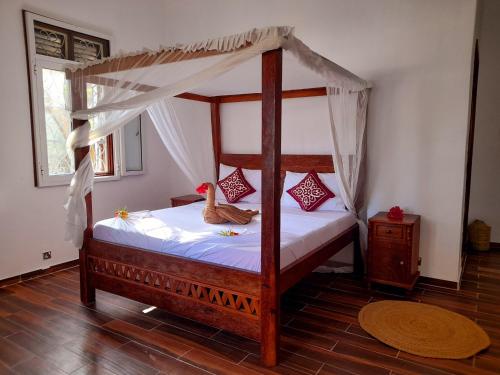 sypialnia z łóżkiem z baldachimem i drewnianą podłogą w obiekcie Culture's apartment w mieście Paje