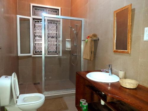 uma casa de banho com um chuveiro, um WC e um lavatório. em Culture's apartment em Paje