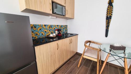 a small kitchen with a table and a microwave at Signal Appartments in Abidjan