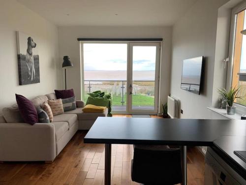 a living room with a couch and a table at Sea View Penthouse Marina Apartment in Portishead