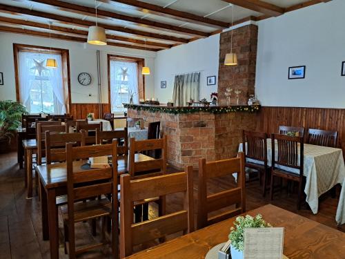 um restaurante com mesas e cadeiras de madeira e uma lareira em Pension U Johnů em Petrovice