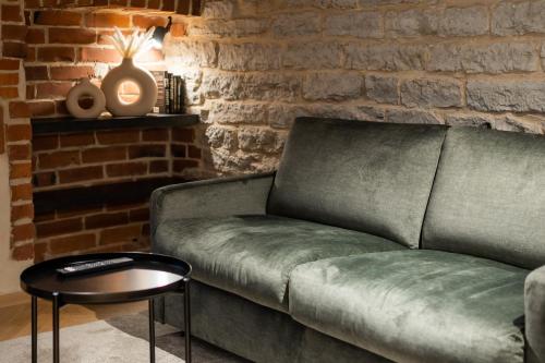 a couch in a living room with a brick wall at N48 Boutique Hotel in Tallinn