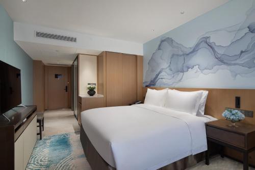 a hotel room with a large bed and a television at Foreign Trade Centre C&D Hotel,Fuzhou in Fuzhou