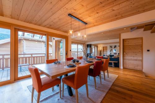 une salle à manger avec une table et des chaises en bois dans l'établissement Chalet Malago ll, au Monêtier-les-Bains